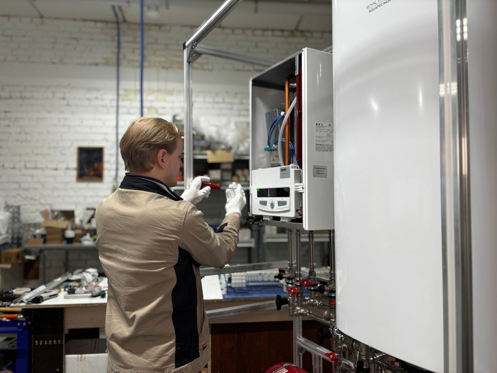 Technician servicing a wall-mounted boiler and water heater